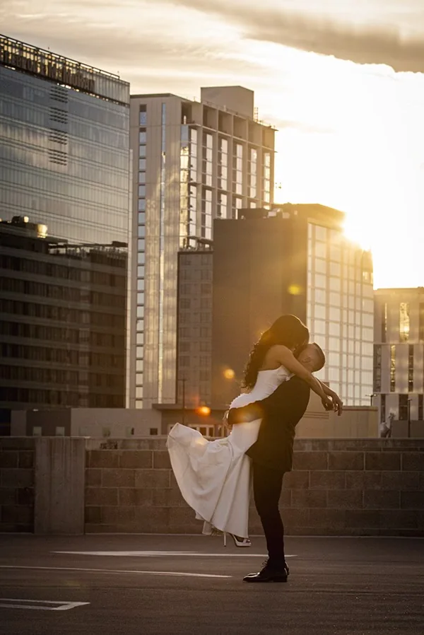 Wedding couple dancing on a rooftop at sunset